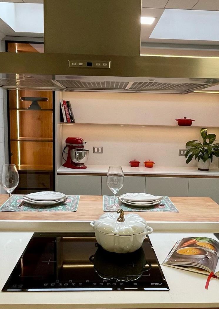 Cocina con isla, cubierta de cuarzo y campana de acero