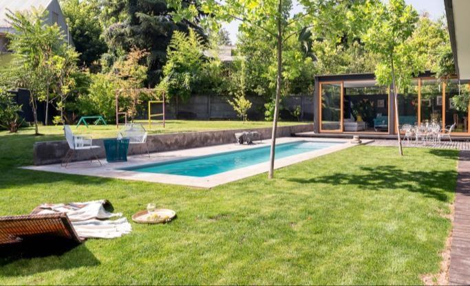 Jardín con piscina, pabellón de vidrio y quincho al fondo